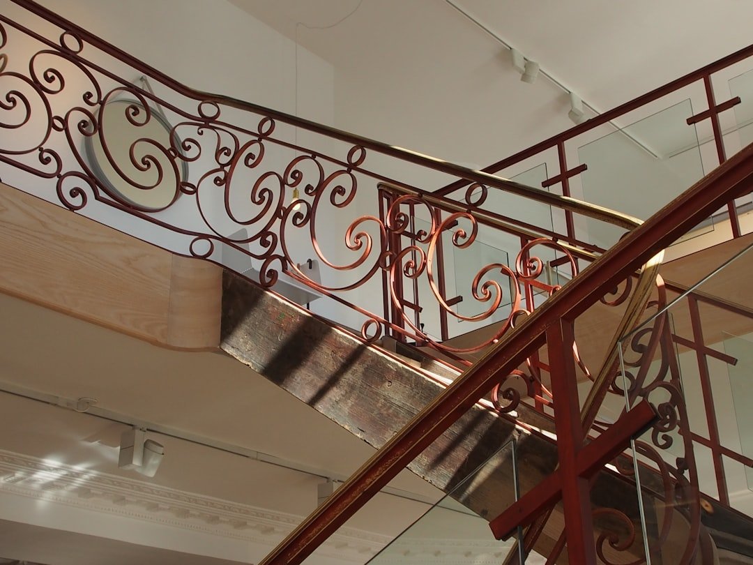 Custom ornamental metal staircase railing with artistic scrollwork in upscale residential setting